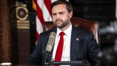 A news-style image of JD Vance speaking at a podium, with subtle U.S., Israeli, and Iranian flags in the background to represent international diplomacy.