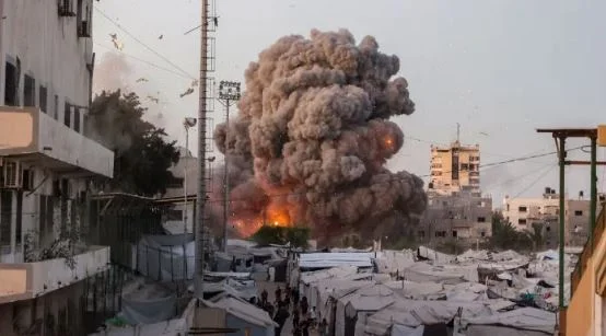 A wide view of Gaza City with damaged buildings, humanitarian aid trucks, and symbolic peace imagery such as a white dove or ceasefire negotiations. (Use a neutral, non-graphic image.)
