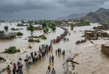 An aerial view of flooded neighborhoods in Punjab with rescue boats evacuating residents, alongside overflowing Chenab River waters and emergency responders assisting affected families.