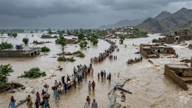 An aerial view of flooded neighborhoods in Punjab with rescue boats evacuating residents, alongside overflowing Chenab River waters and emergency responders assisting affected families.