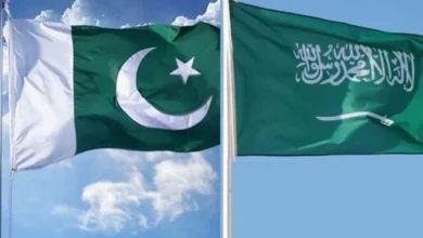Pakistan and Saudi Arabia flags with U.S. dollar currency and financial charts representing the three-year extension of Pakistan's $5 billion Saudi loan.