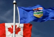 Canadian and Alberta flags representing the debate over Alberta separation from Canada.