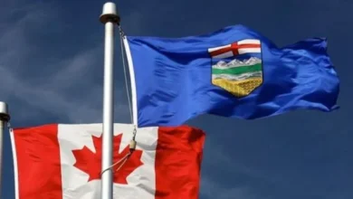 Canadian and Alberta flags representing the debate over Alberta separation from Canada.