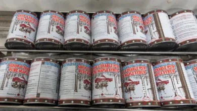 Cans of maple syrup stacked on store shelves as Quebec producers face rising demand and depleted strategic reserves.